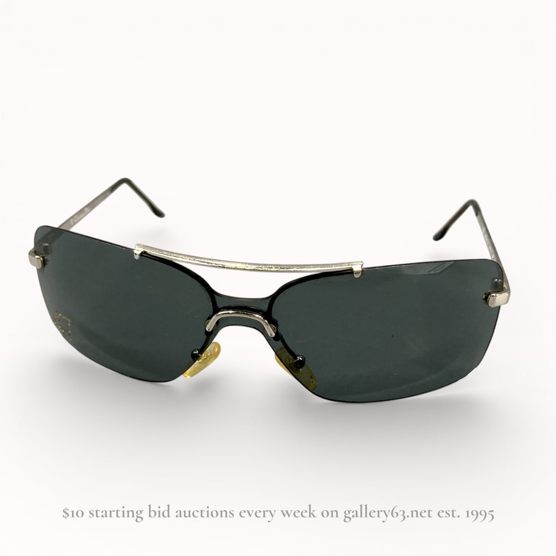 Dior Shield-Style Sunglasses, Model 47 26R 125: Authentic Christian Dior sunglasses having a shield-style dark tinted lens set within a black and silver-tone metal frame. Design featuring a curved single lens profile with integrated nose pads and s