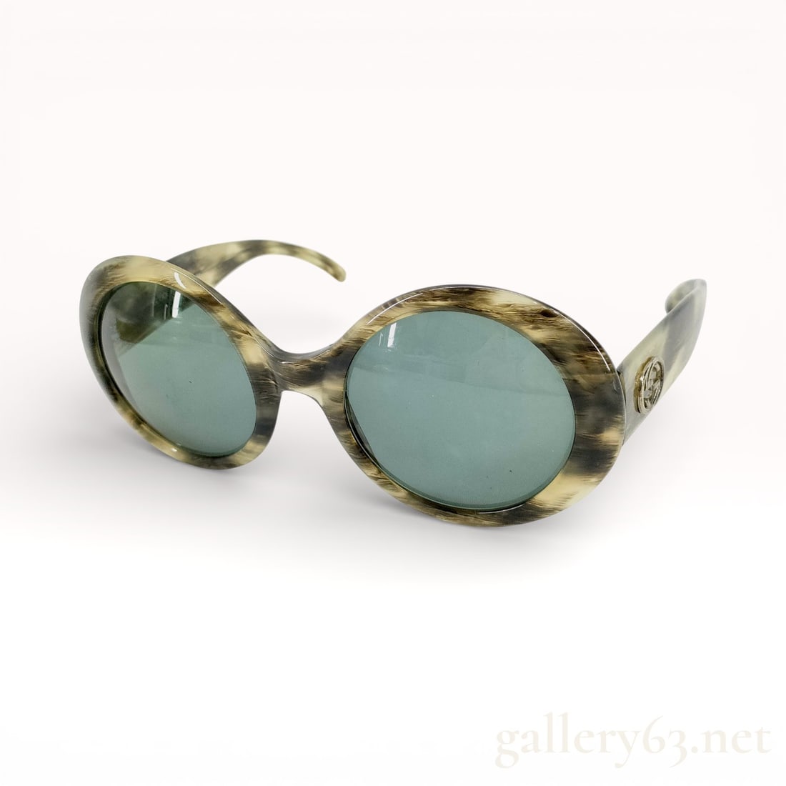 Vintage Gucci Horn-Pattern Acetate Round Oval Sunglasses: Vintage Gucci sunglasses featuring a round oval frame in a horn-pattern acetate. Design includes green-tinted lenses and curved arms with Gucci medallion detail at the temples. Oversized silhouette wi