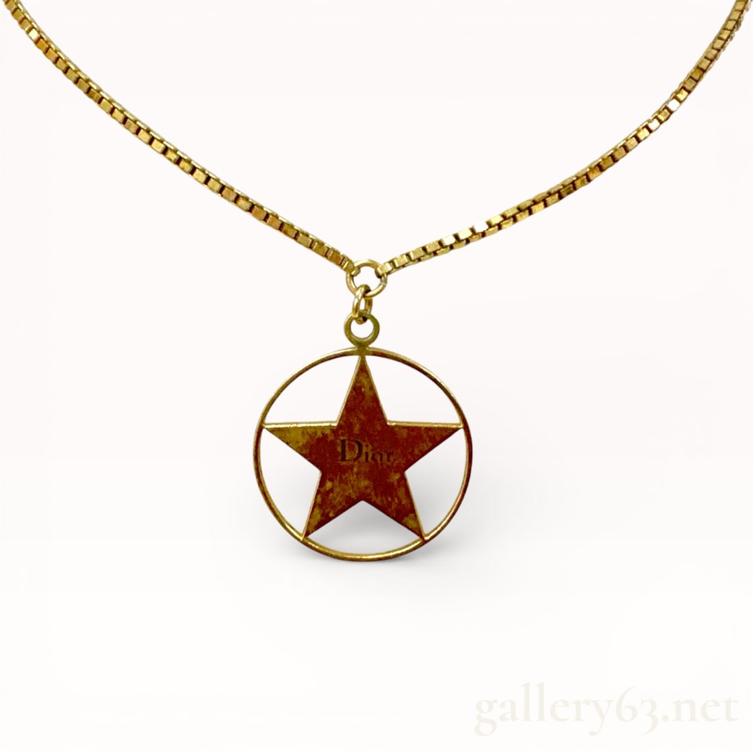 Dior Gold Plated Enamel Star Pendant Necklace: Authentic Dior necklace featuring a gold-tone box link chain suspending a circular pendant. Pendant formed with an open round frame enclosing a five-point star motif at center. Star finished in
