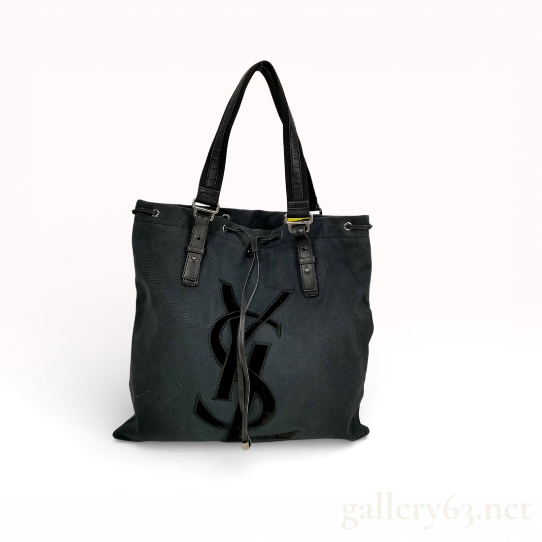 Yves Saint Laurent Kahala Black Canvas Tote Bag with Velvet YSL Logo: Yves Saint Laurent Kahala tote bag having a structured black canvas body. Front panel featuring an applied velvet YSL monogram in tonal black. Open-top construction with an adjustable drawstring-style