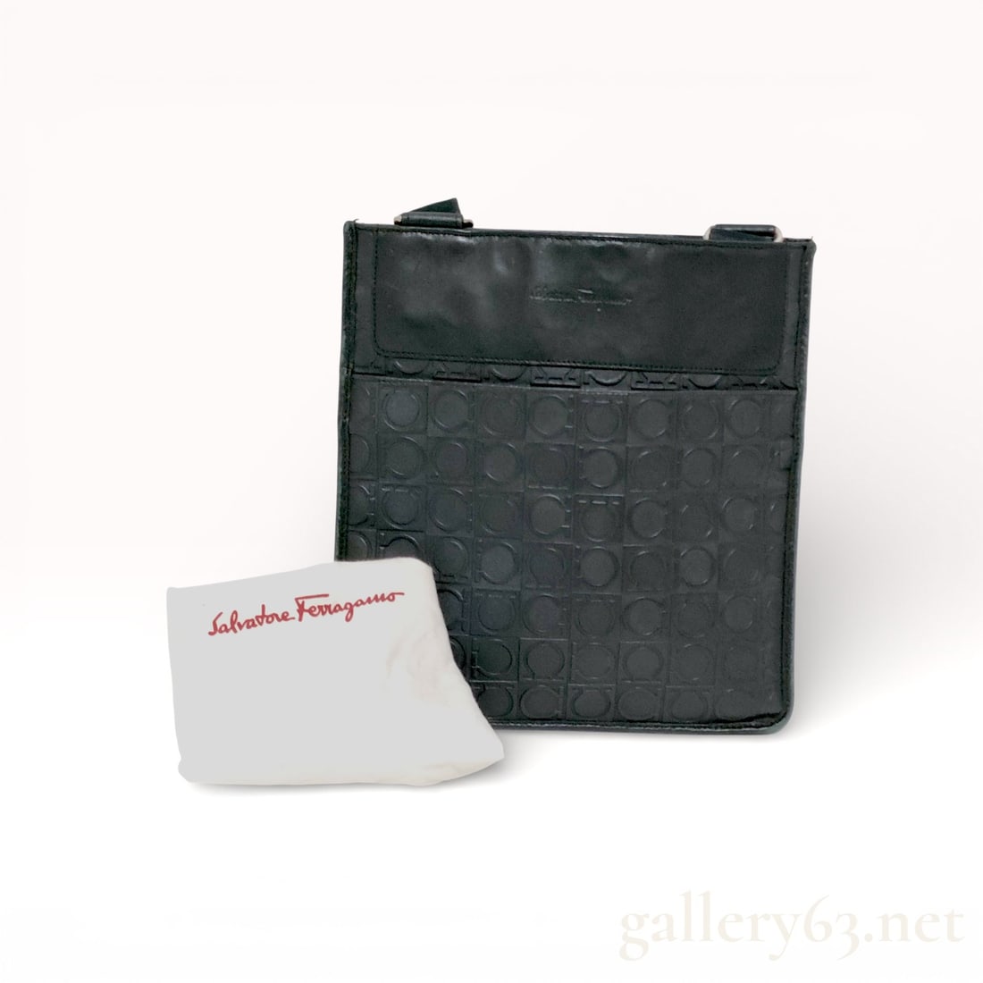 Salvatore Ferragamo Gancini All-Over Gussetless Shoulder Bag: Salvatore Ferragamo shoulder bag having an all-over Gancini patterned textile exterior in black. Slim, gussetless silhouette trimmed with smooth black leather at the top panel and edges. Flat profile