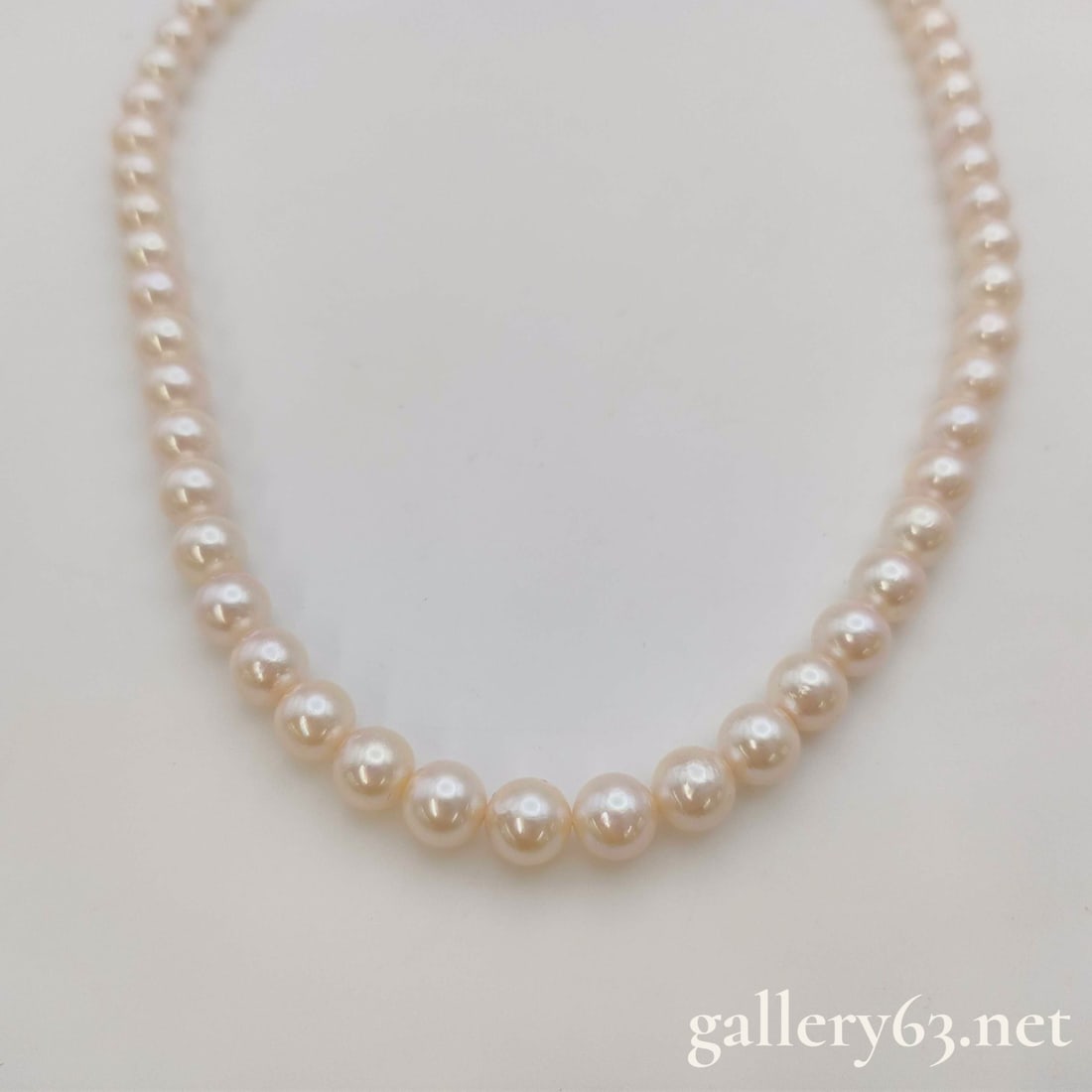 Akoya Pearl Necklace 7.0mm-7.4mm SV 32.8g: Akoya pearl necklace strung with round pearls presenting a soft champagne-pink luster. Pearls measuring approximately 7.0–7.4 mm in diameter. Continuous strand forming a balanced, classic line aroun
