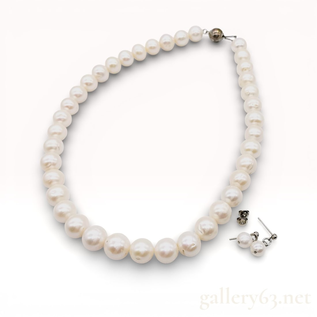 12mm Freshwater Pearl Strand and Pair of Earrings with Case and Gem Report: Strand of freshwater pearls measuring 12mm each and accompanied by a matching pearl of pearl stud earrings with post backs. Pearls showing soft luster and natural surface characteristics typical of fr