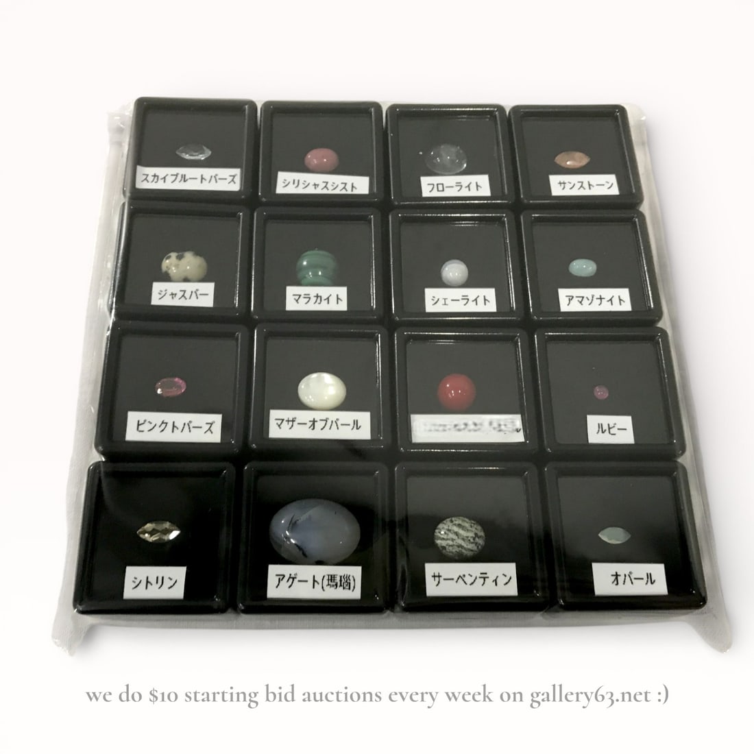 Sixteen Faceted and Cabochon Gemstones - Ruby, Citrine, Opal etc.: Group of polished gemstone cabochons presented in individual black display cases with Japanese identification labels. Assortment including stones labeled as opal, ruby, citrine, pink topaz, sky blue t