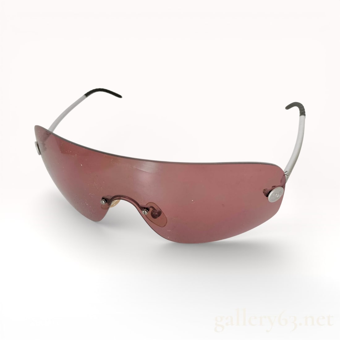 Chanel CC Logo Smoky Rose Shield Sunglasses, Model L4729: Shield-style sunglasses by Chanel featuring a single curved lens in a rose-tinted hue. Slim metal arms terminating in black acetate tips. Temple hinges accented with circular Cocomark logo hardware. L