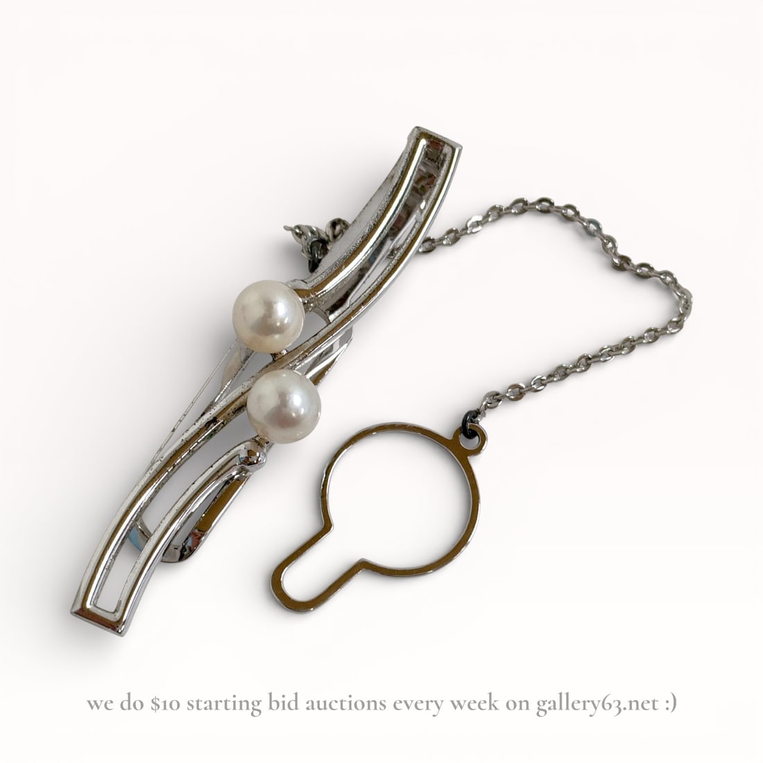 Mikimoto Pearl Tie Pin in Sterling Silver: Tie pin by Mikimoto featuring a curved sterling silver bar set with two round white pearls. Polished silver-tone surface with a layered linear form emphasizing the pearl accents. Chain and loop backin