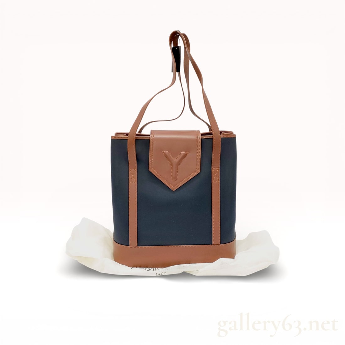 Yves Saint Laurent Tagged Nylon and Leather Tote Bag: Yves Saint Laurent tote bag having a structured nylon body with leather trim and base. Design featuring leather shoulder straps, leather corner reinforcements, and a leather front flap accent embossed