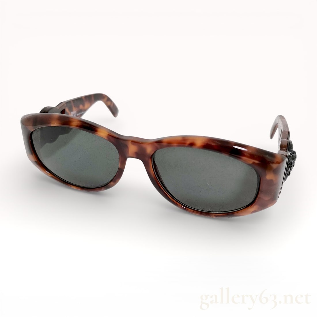 Gianni Versace Tortoiseshell Sunglasses with Medusa Temple Detail and Case: Authentic Gianni Versace sunglasses having a tortoiseshell acetate frame with softly rounded rectangular lenses. Design featuring dark tinted lenses and sculptural Medusa head hardware at each temple.