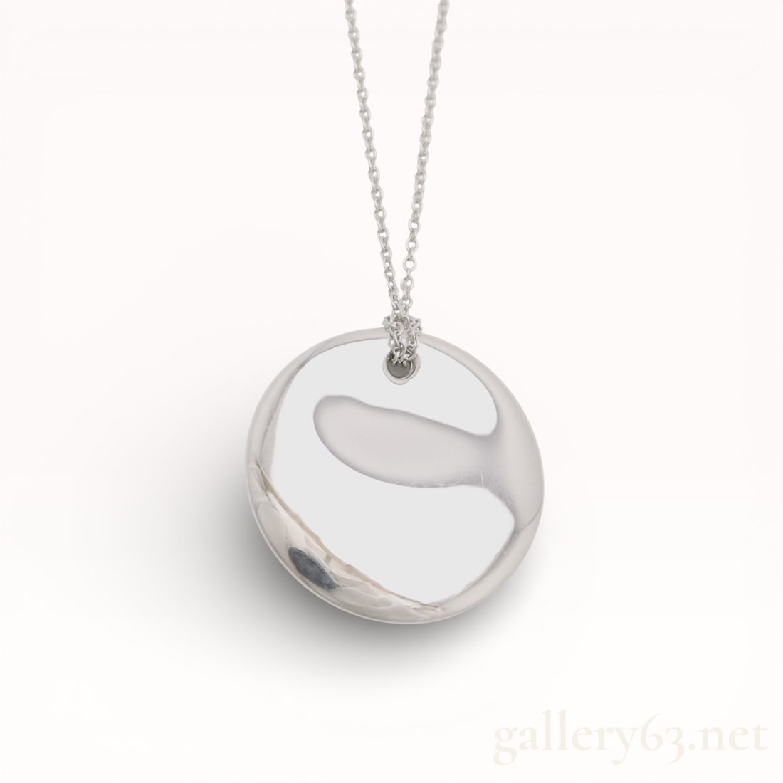 Tiffany&Co. Round Elsaperetti .925 Silver Necklace: Authentic Tiffany&Co. silver chain and a round pendant of sculptural form, featuring an asymmetrical recessed cutout within a smooth domed surface. Design presenting a high-polish finish with soft