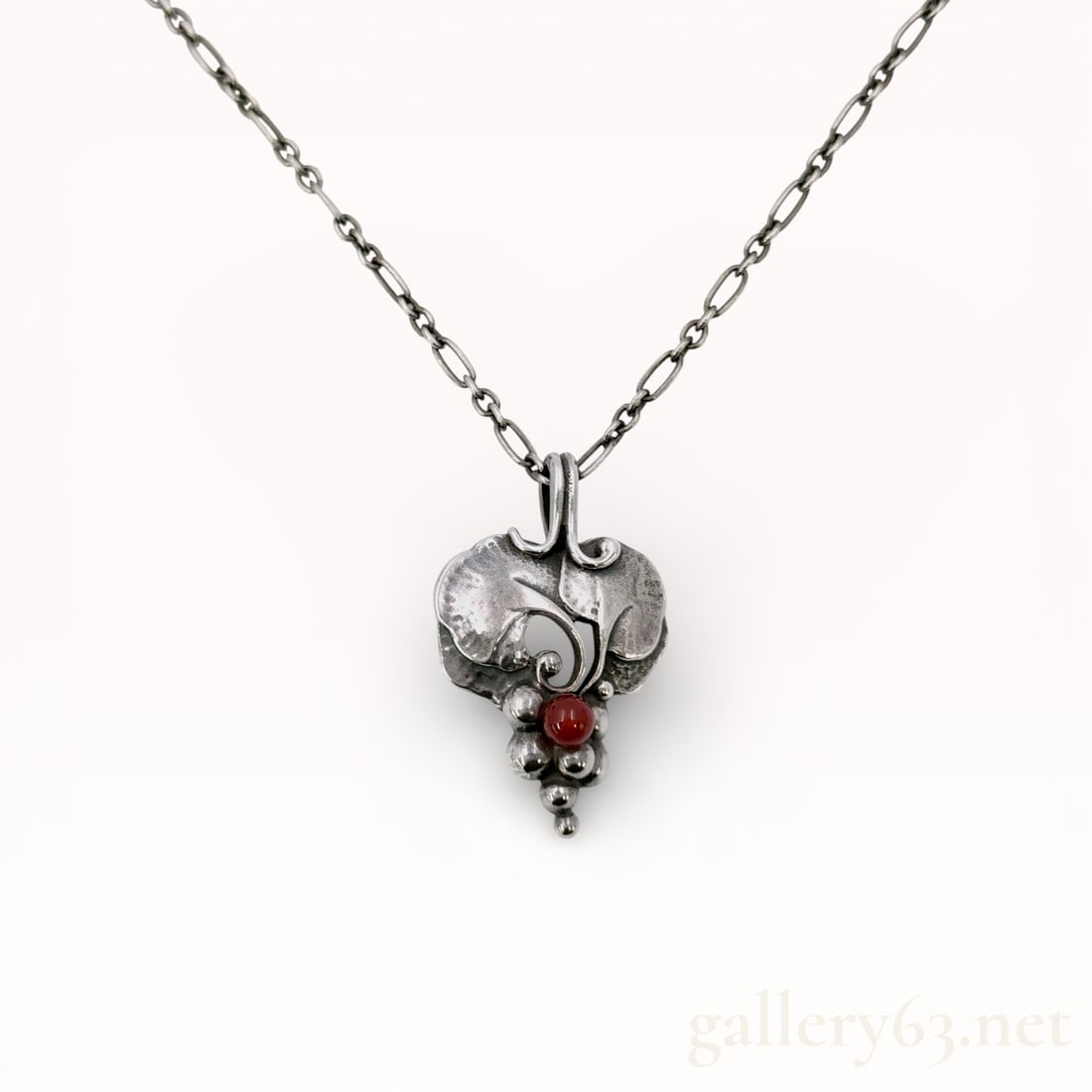 Georg Jensen .925 Silver Akaishi 1996 Necklace With Box: Authentic Georg Jensen Necklace. Silver 20.5 inch chain and a sculptural pendant of organic form, featuring layered leaf-like elements with textured surfaces. Design including a small round red accent