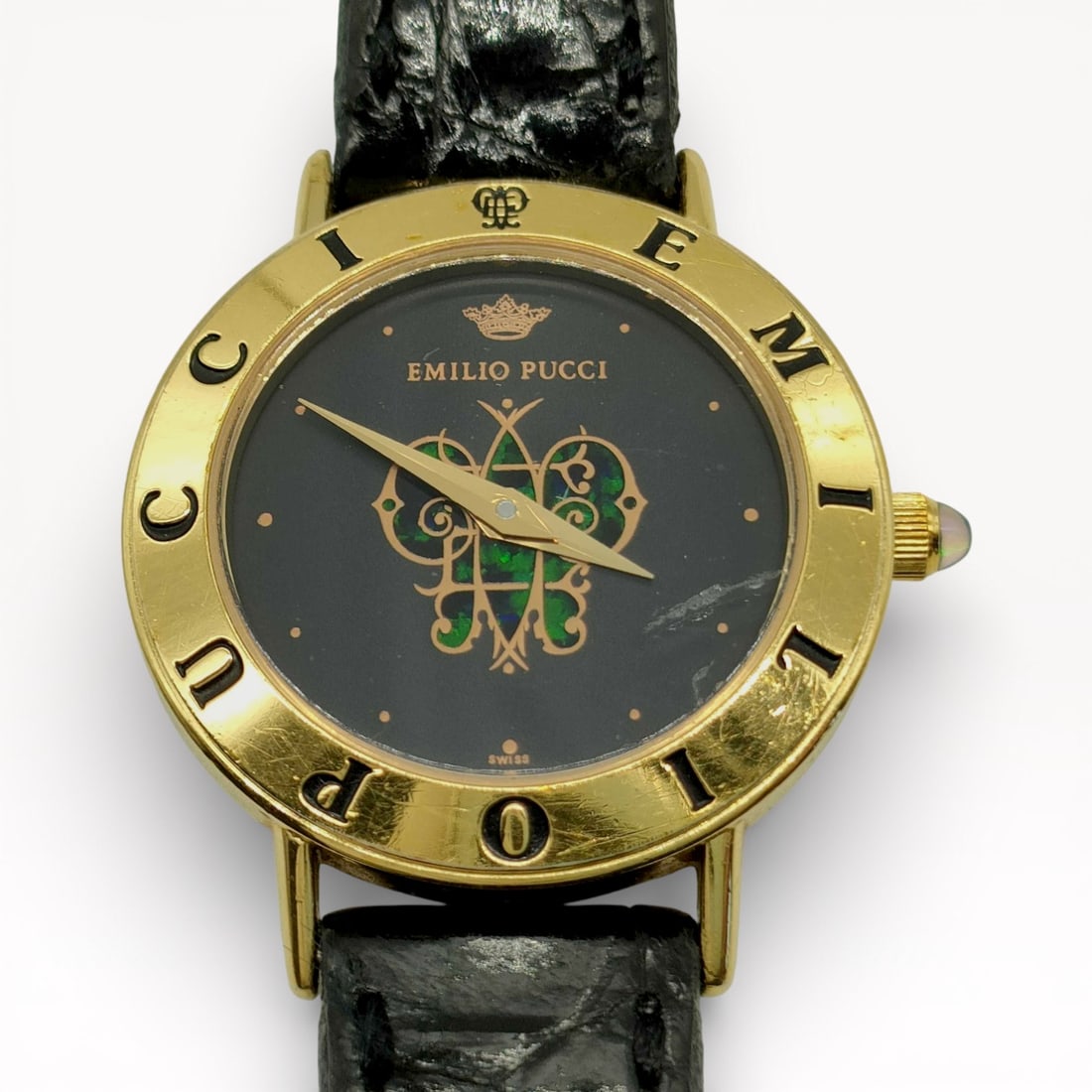 Emilio Pucci Swiss Quartz Wristwatch with Black & Multicolor Enamel Dial and Leather Strap: Authentic Emilio Pucci Swiss quartz wristwatch with a black dial featuring a central decorative motif, applied dot hour markers, and gold-tone hands. Round case with a fixed bezel engraved EMILIO PUCC