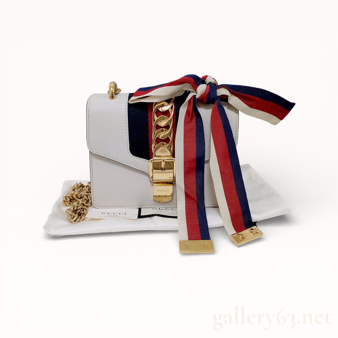 Gucci Sylvie Sherry White Chain Shoulder Bag: Authentic Gucci shoulder bag having a white-toned exterior. Rectangular form featuring a structured body. Front presenting decorative hardware and a metal chain element. Chain shoulder strap present,