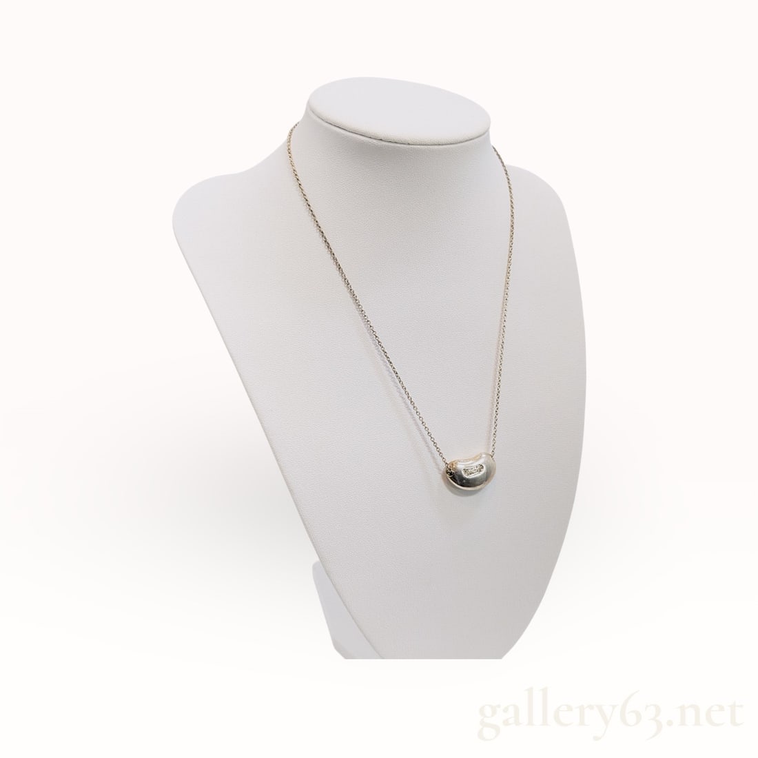 Tiffany&Co. Bean .925 Sterling Silver Necklace: Authentic Tiffany&Co. fine silver chain and a small bean-form pendant with a smooth domed surface. Design featuring an organic rounded silhouette with high-polish finish. Construction including a
