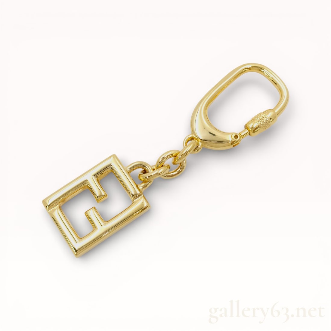 Fendi FF Logo Metal Keychain With Box: Authentic Fendi gold metal assembly keychain with a spring-loaded carabiner-style clip connected by a short chain to a square open-frame pendant. Design featuring an interlocking double-letter F logo