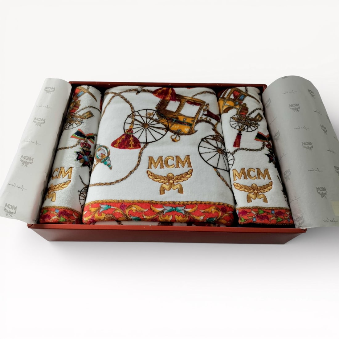 MCM Printed Cotton Towel Gift Set with Logo Motif - Brand New: Authentic MCM towel gift set in printed cotton. Set with multiple coordinating towels featuring the MCM logo and illustrated motif, finished with patterned borders. Presented in the original MCM gift