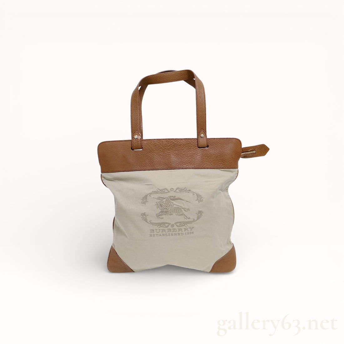 Burberry Stonewall Equestrian Tote: Authentic Burberry tote-style handbag, having a light-colored textile body featuring a printed emblem and surrounding text. Upper edge, handles, base corners, and side tabs are leather, finished in a