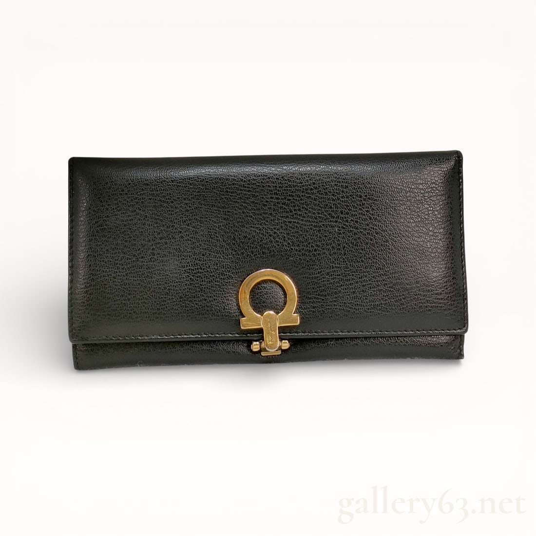 Salvatore Ferragamo Gancini Long Wallet: Authentic Ferragamo long wallet. Rectangular black leather body with a pebbled surface finish. Design featuring a front flap secured by a gold-tone Gancini style clasp mounted at center. Construction