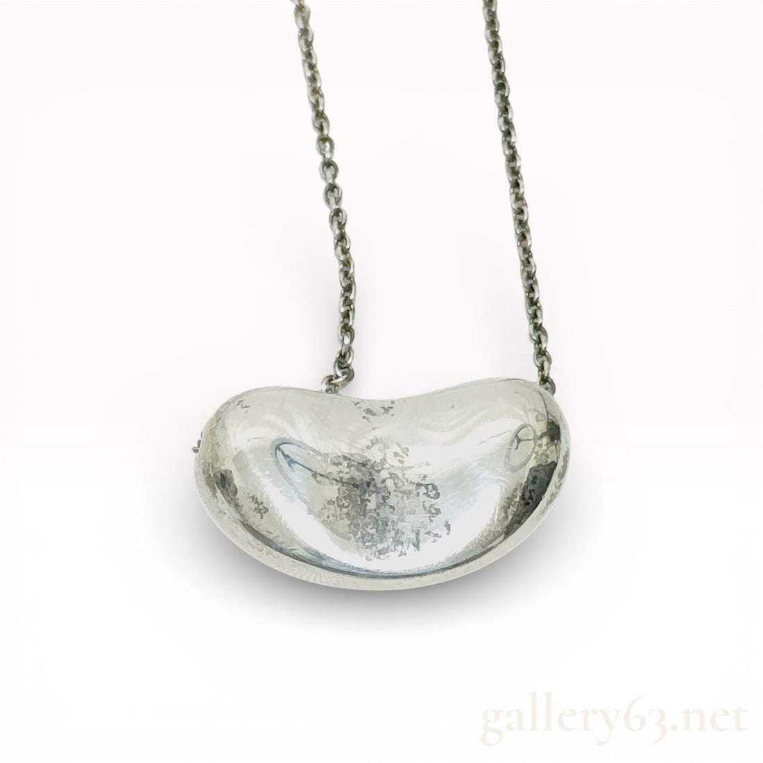 Tiffany & Co. Sterling Silver Bean Pendant Necklace: Tiffany & Co. bean pendant necklace crafted in sterling silver. Polished bean-form pendant suspended from a fine sterling silver chain. Pendant reverse and clasp marked “Tiffany & Co.”