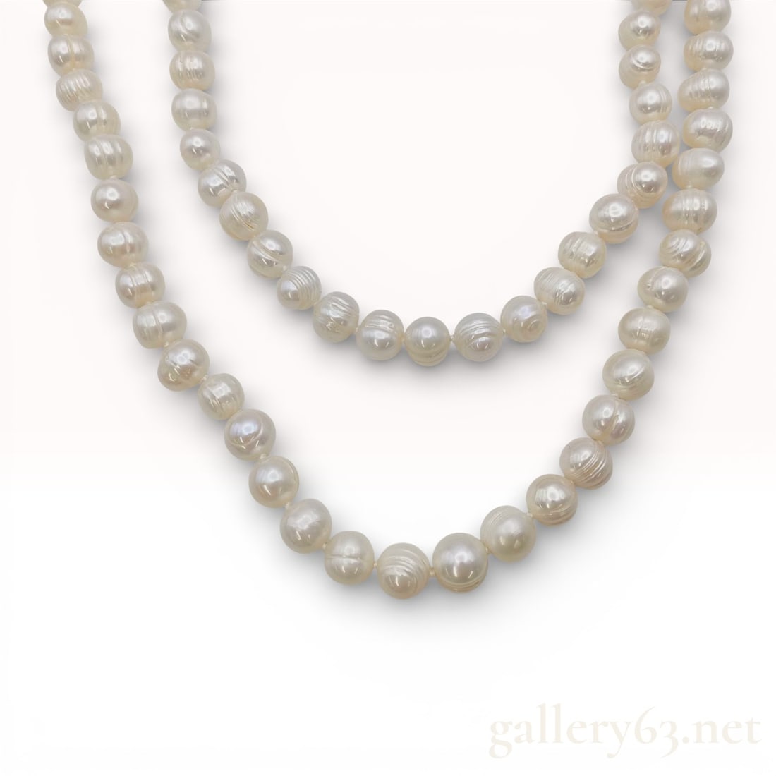 Opera Length Individually Knotted 8.0-10.0mm Semi-Round Cultured Pearl Strand Necklace: Long opera-length necklace featuring semi-round cultured pearls graduating in size. Strand displays soft white luster with subtle organic variation across each pearl. Extended length allows for versat