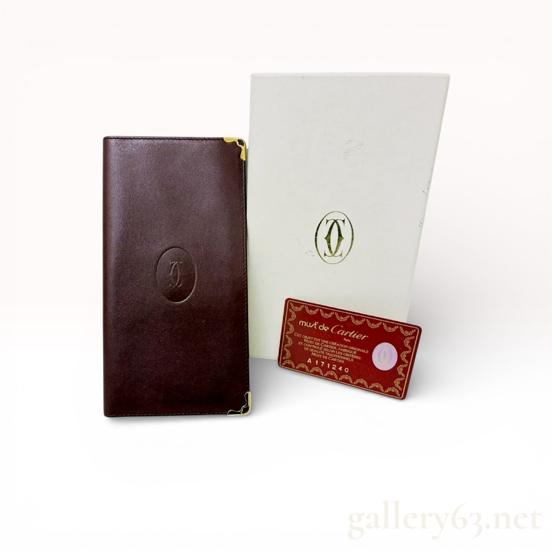 Must de Cartier Bordeaux Long Bi-fold Wallet With Box and Certificate Card: Authentic Cartier long wallet in Bordeaux leather, featuring a smooth exterior with an embossed Cartier monogram medallion to the front. The wallet is finished with gold-tone metal corner hardware and