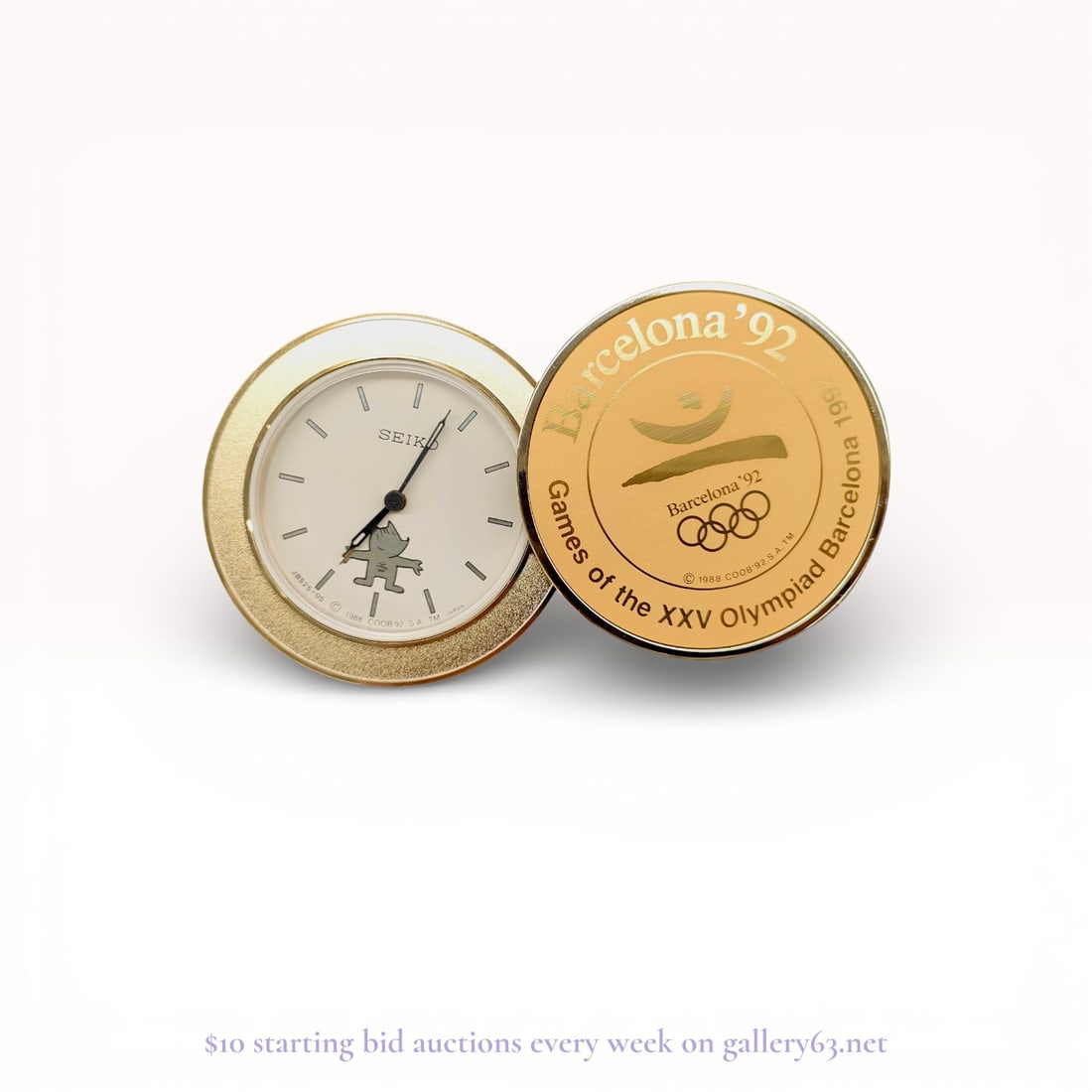 Seiko Barcelona '92 Olympic Games Commemorative Desk Clock: Authentic Seiko desk clock in a gold-tone circular case, featuring a white dial with applied baton hour markers and black hands. The dial is signed Seiko and decorated with the Barcelona 1992 Olympic