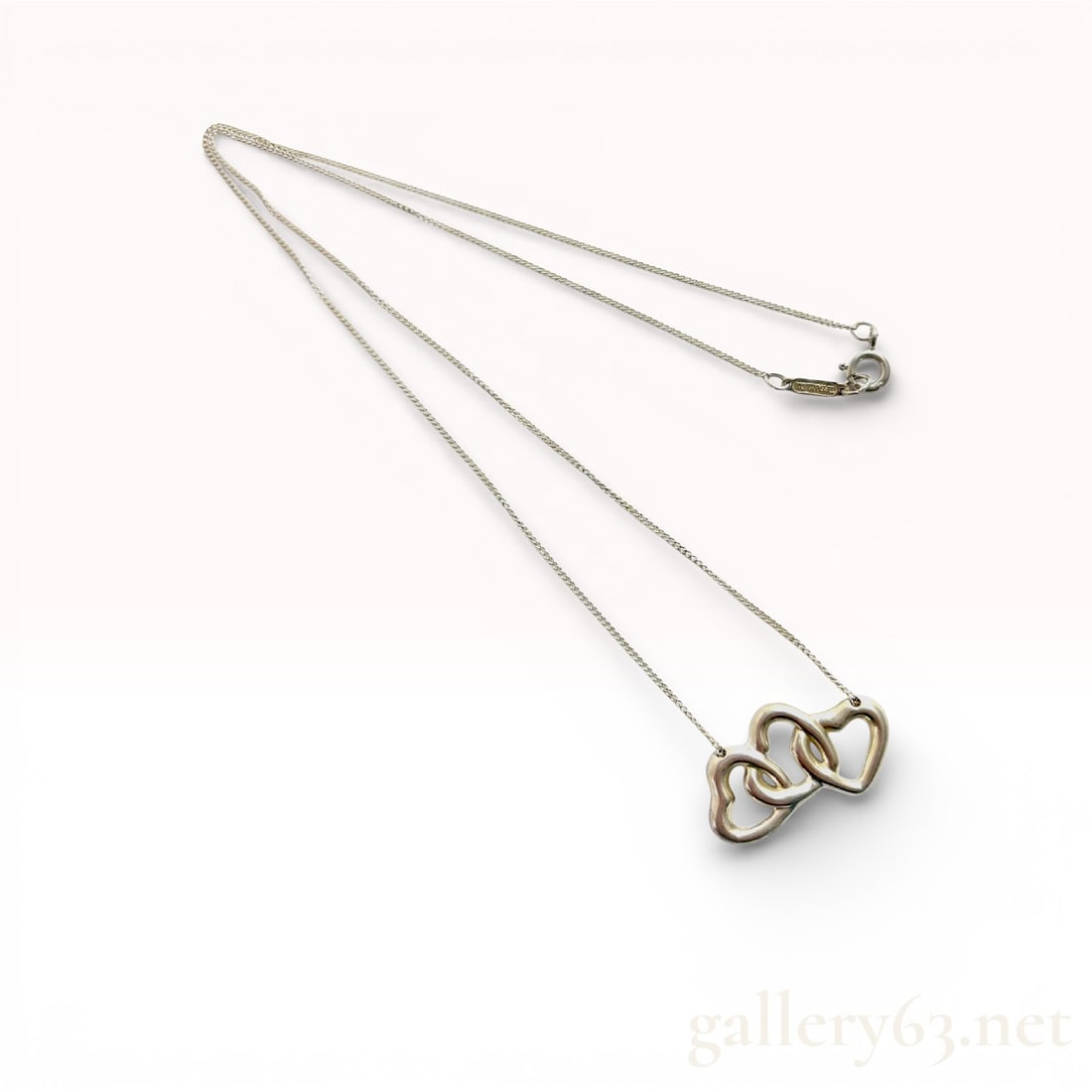 Tiffany & Co. Sterling Silver Triple Open Heart Pendant Necklace, 3.8g: Authentic Tiffany & Co. silver necklace featuring an interlocking triple heart pendant design. The pendant is suspended from a fine chain with a spring ring clasp, presenting a clean, balanced sil