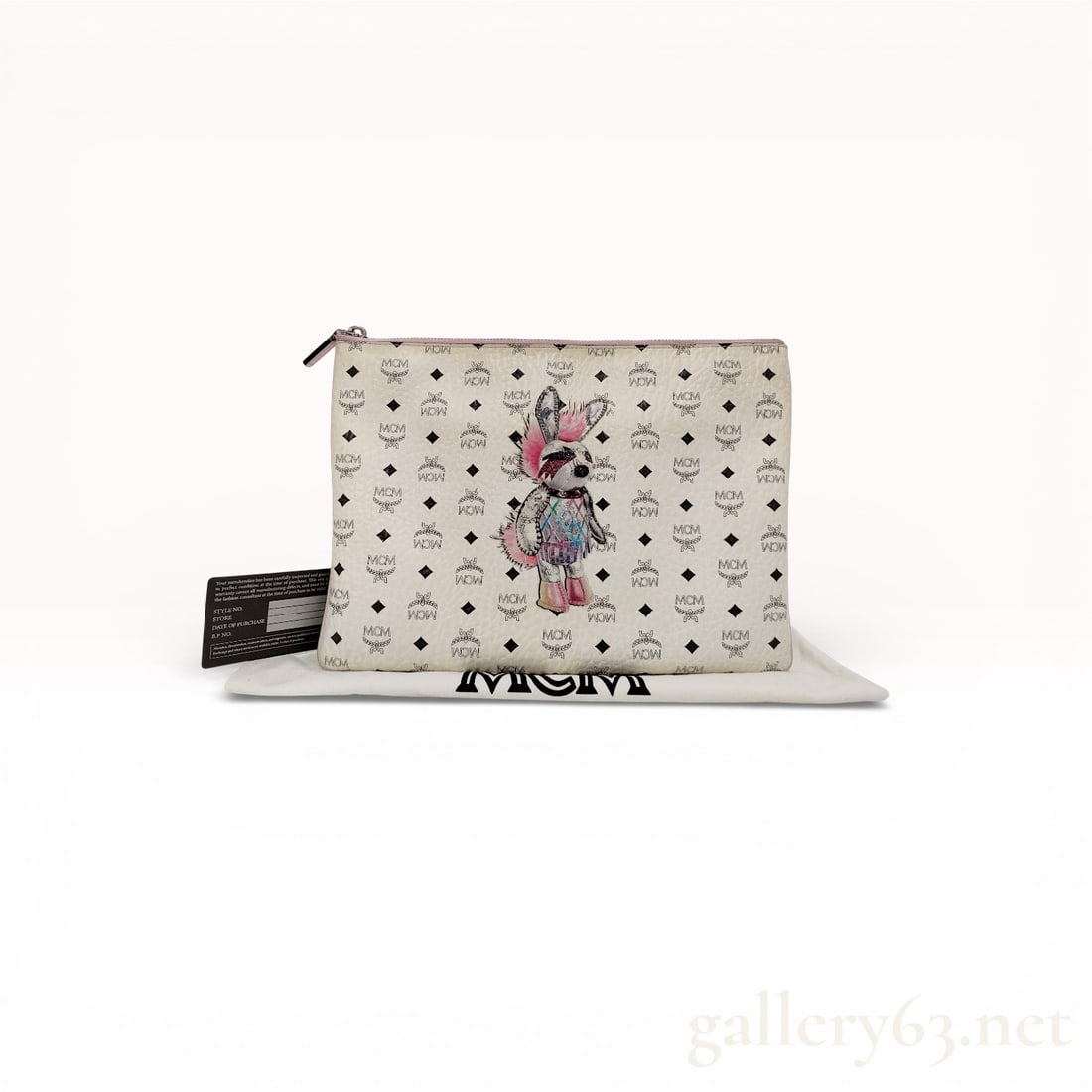 MCM Visetos Coated Canvas Zip Pouch Clutch in White Featuring Illustrated Bunny Motif: Authentic MCM Visetos zip pouch clutch featuring a white coated canvas exterior with signature monogram print throughout. Front panel having an illustrated bunny motif accent. Slim rectangular silhoue