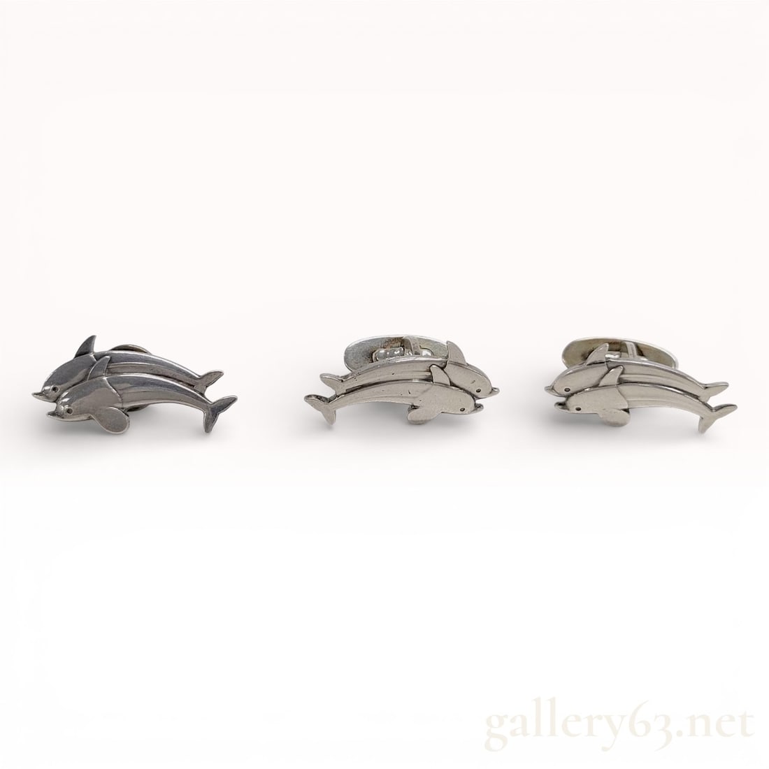 Georg Jensen Dolphin Motif Cufflinks and Matching Tie Tack Set in Sterling Silver: Georg Jensen accessory set featuring a pair of dolphin motif cufflinks with sculptural polished detailing. Set accompanied by a matching dolphin motif tie tack. Pieces completed with secure toggle