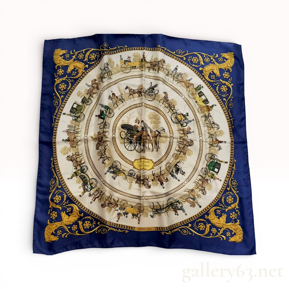 Hermès “Walk to Longchamp?? Carré 90 Silk Scarf in Navy and Gold: Hermès Carré 90 silk scarf featuring the “Walk to Longchamp” motif in navy, ivory, and gold tones. Design having concentric equestrian and carriage imagery with ornate border d