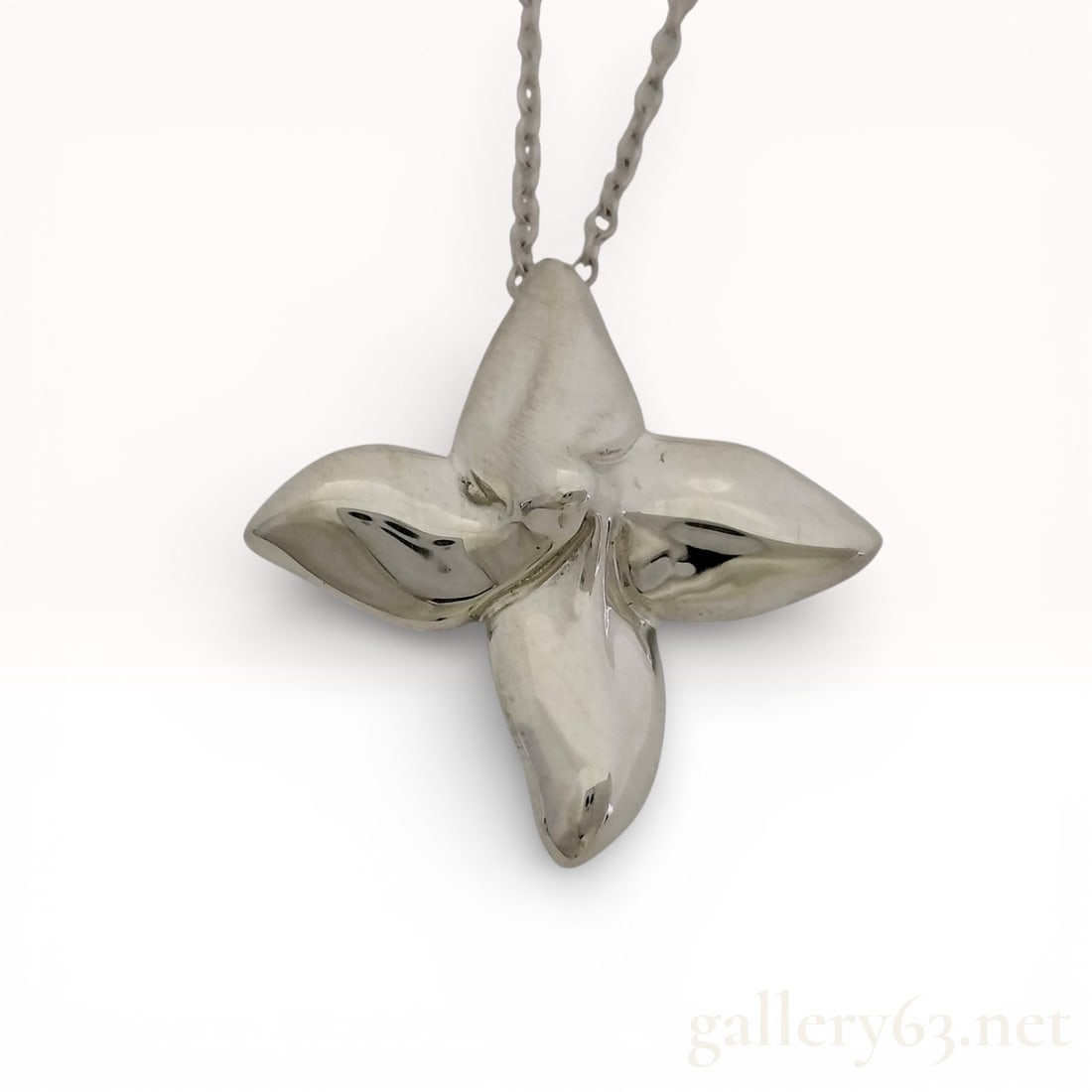 Tiffany & Co. Poinsettia Flower Pendant Necklace in Sterling Silver 16": Tiffany & Co. pendant necklace featuring a sculptural poinsettia flower motif in polished sterling silver. Pendant suspended from a fine sterling silver chain with secure clasp closure. Design