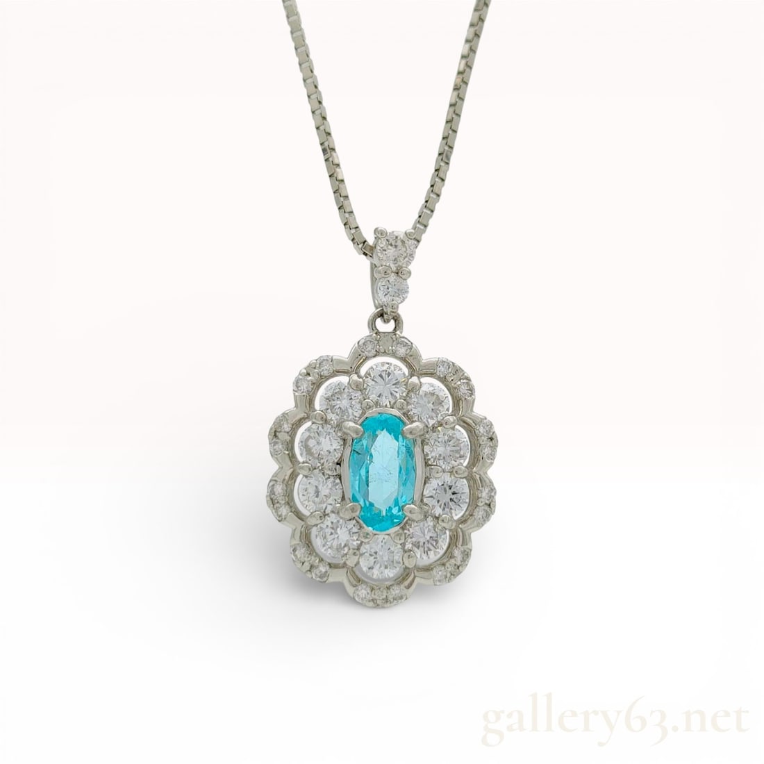 Platinum Paraiba Tourmaline and .56ctw Diamond Halo Pendant Necklace 16-20": Platinum pendant necklace featuring an oval-cut .25ct Paraiba tourmaline center stone. Necklace having a scalloped double halo design accented by round brilliant-cut diamonds totaling .56cts surroundi