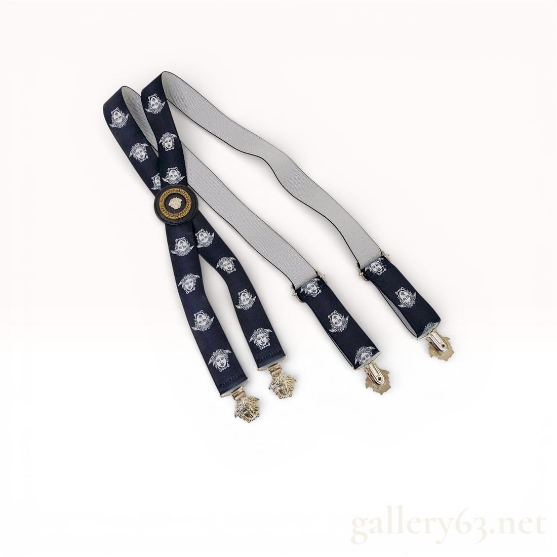 Vintage Gianni Versace Medusa Logo Suspender: Versace suspenders featuring a dark woven strap design with repeating Medusa head motifs. Center back accented by a circular Medusa emblem detail. Ends fitted with gold-tone clip hardware for secu