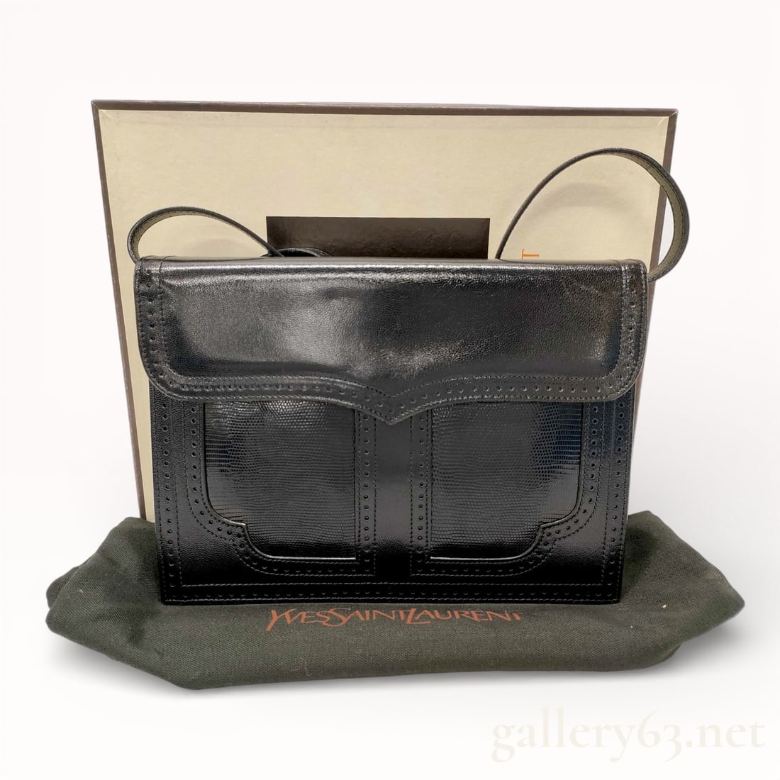 Yves Saint Laurent Lizard-Skin One Shoulder Formal Bag: Authentic.Yves Saint Laurent one shoulder bag having a structured rectangular form crafted in black lizard leather. Front featuring stitched panel detailing and a flap-style design. Set with a slim le