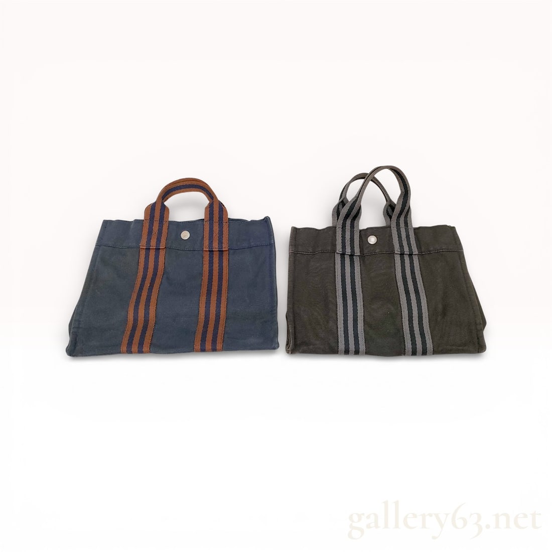 Hermes Fourre Tout PM Set of 2: Authentic Hermes tote set having two canvas handbags featuring striped webbing handles. First bag having a navy body featuring brown and rust vertical stripes and a silver-tone snap at the center.