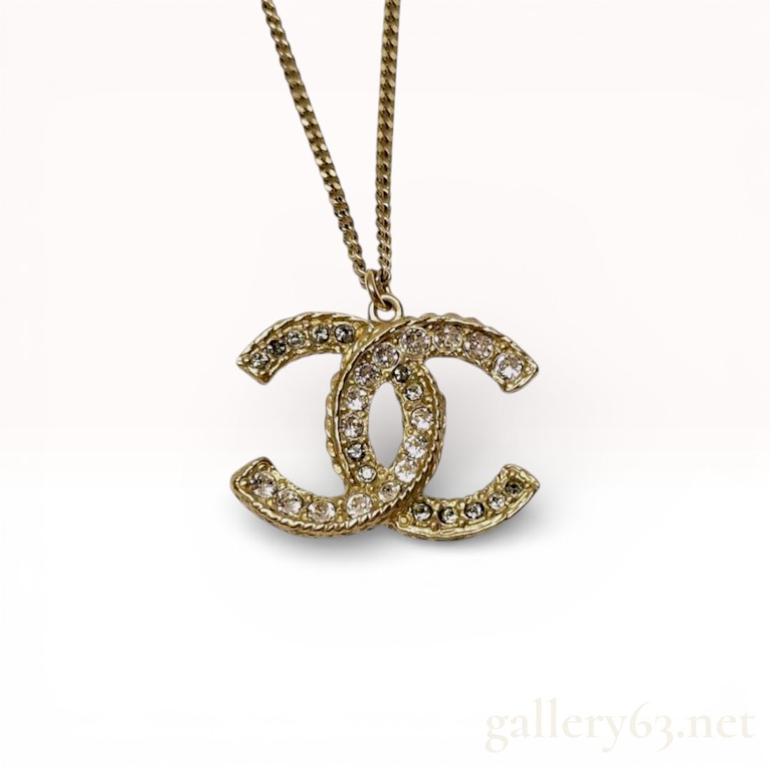 Chanel 2015 Cruise Line CC Rhinestone Necklace 26": Authentic Authentic Chanel necklace having a gold-tone chain featuring a CC pendant set with rhinestones. Pendant featuring intertwined C logos with textured gold-tone finish along edges. Chain fea