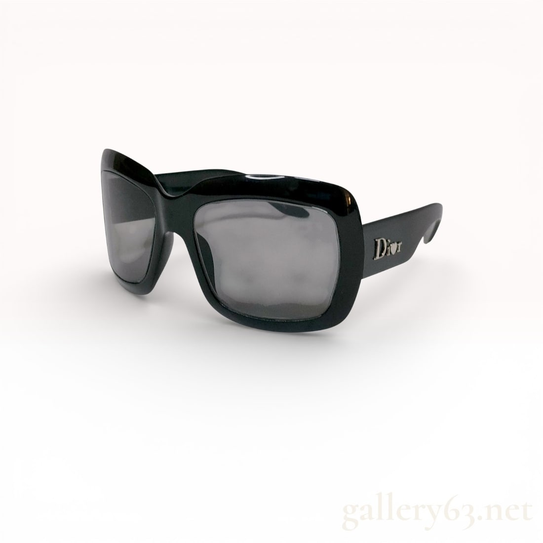 Dior Black Oversized Square Sunglasses with Logo Temples: Dior sunglasses having an oversized square frame in glossy black acetate. Dark gray lenses set within thick, sculptural rims. Wide temples in matching black acetate featuring raised Dior logo letterin