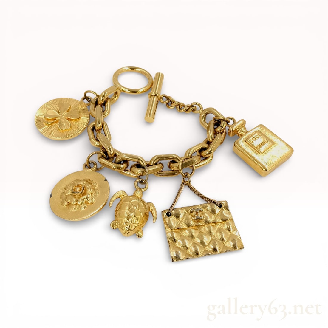 Vintage Chanel Gold Plated Charm Bracelet Toggle Clasp 7": Authentic Chanel gold-tone charm bracelet adorned with iconic motifs including a quilted handbag, lion medallion, turtle, starfish, and No.5 perfume bottle charm. Features toggle clasp closure and cla