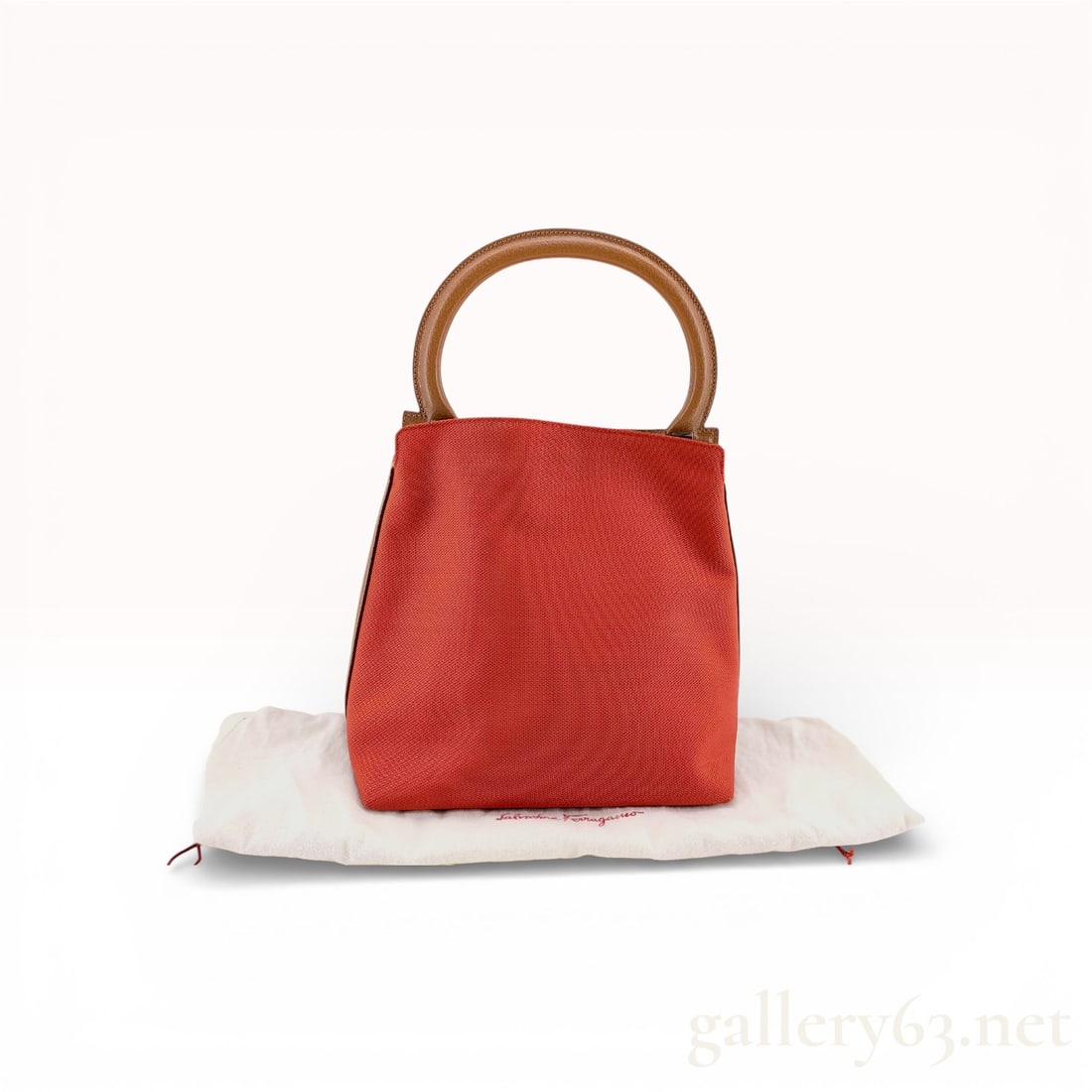 Salvatore Ferragamo Gancini Red Canvas Handbag: Authentic Ferrafgamo Handbag in red pebbled canvas with soft structured body. Compact bucket/box silhouette with flat base. Single circular top handle in tan leather. Open top with magnetic snap closu