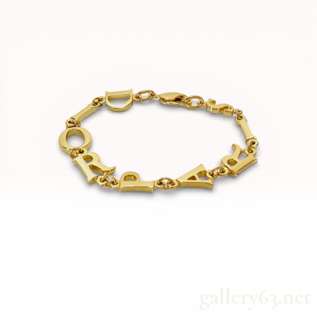 Dior Alphabet Logo Bracelet Gold Tone 7": Dior bracelet having sequence of gold-tone metal links shaped into stylized letters forming repeating D I O R motif around entire strand. Letters presenting smooth polished surfaces with defined edges