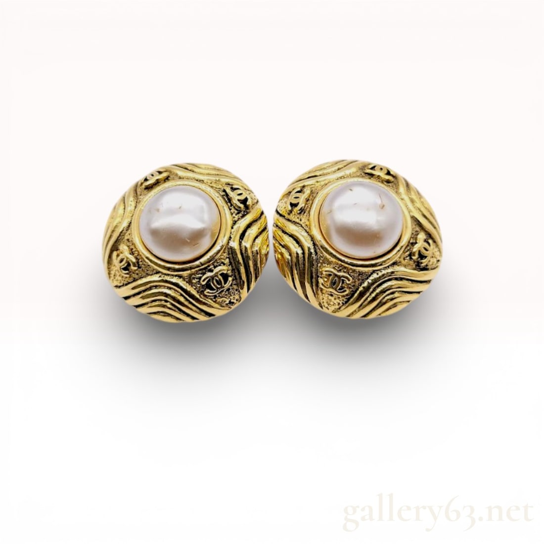 Chanel Costume Pearl & Gold Plated Round Vintage Earring Clips 2 5: Authentic Chanel earrings having round gold-tone frames featuring wave-patterned textured surfaces and central faux pearl cabochons. Clip-on backs featuring Chanel hallmark and season stamp. Surfac