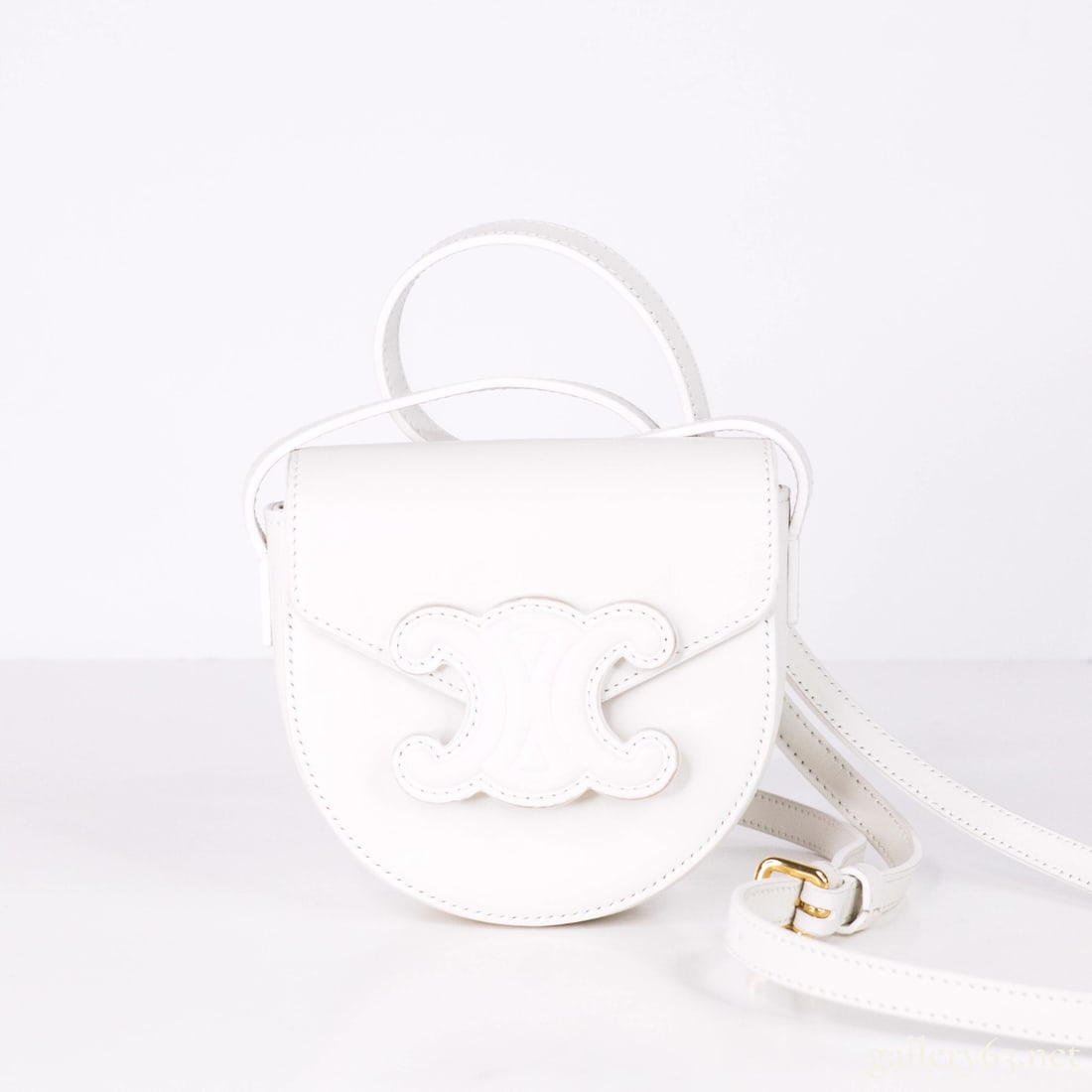 CELINE Mini Besace Cuir Triomphe White Leather Bag: This refined shoulder bag from CELINE features the signature Triomphe clasp in a compact silhouette, crafted from smooth white leather. Elegant and understated. Ideal for day-to-night transitions.