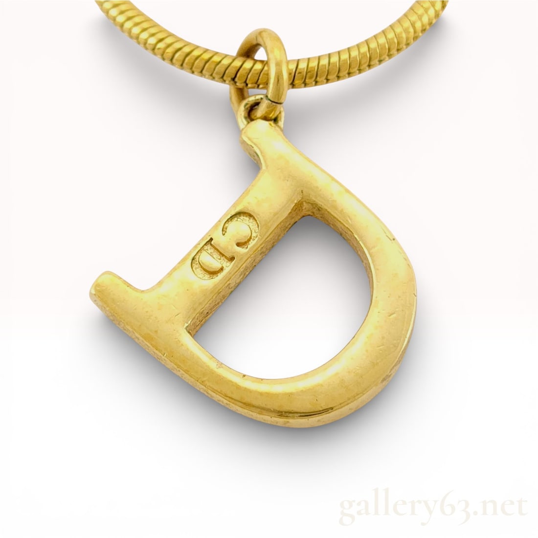Dior Gold-Plated “D?? Pendant Necklace perfect for Dads or Donnas: Authentic Dior Gold-Tone “D” Pendant Necklace Necklace featuring a gold-tone chain with a large “D” pendant engraved with CD on the side. Pendant hangs from a smooth snake-style ch
