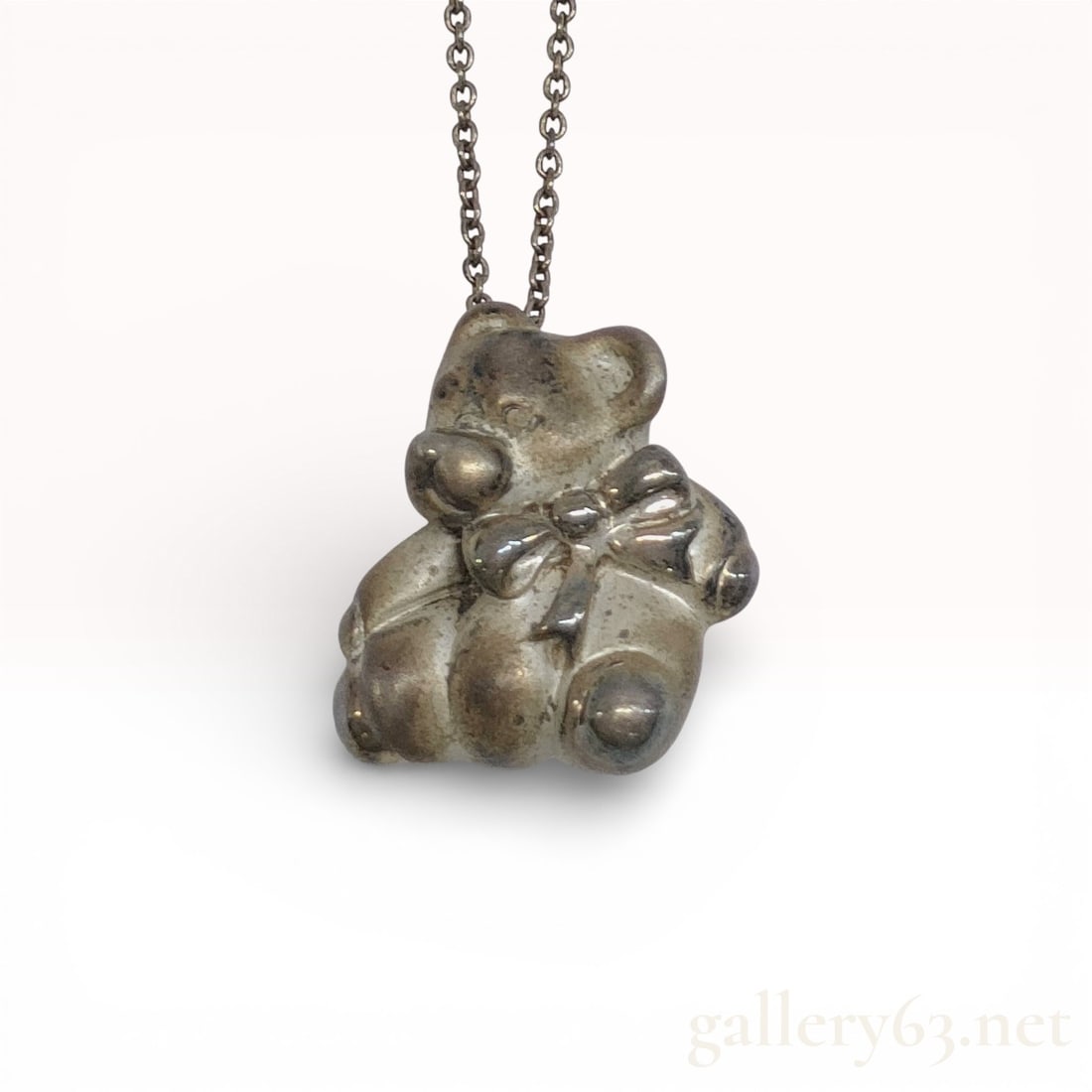 925 Sterling Silver Tiffany & Co. Bear Necklace: Tiffany & Co. necklace in sterling silver featuring a three-dimensional bear pendant with bow detail on a fine link chain. Pendant stamped “TIFFANY & CO. 925” on reverse. Spring ring c