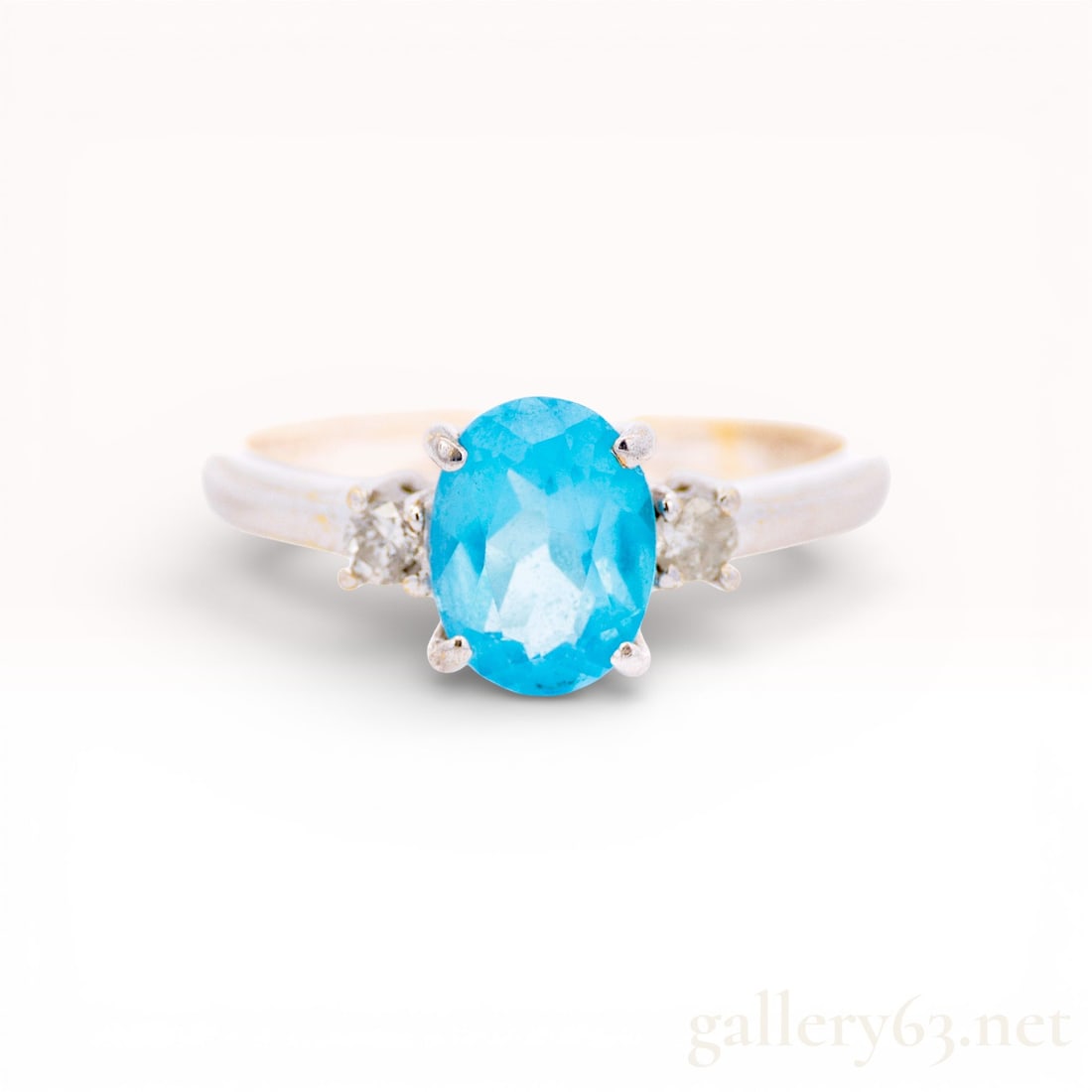 18KWG Blue Topaz & Diamond Ring, Size 7: 18k White-gold ring set with an oval 1.20ct blue topaz at center. Topaz flanked by two small round diamonds on each side, .10ctw. Four-prong center setting on a polished band. approx. 3.0g. size