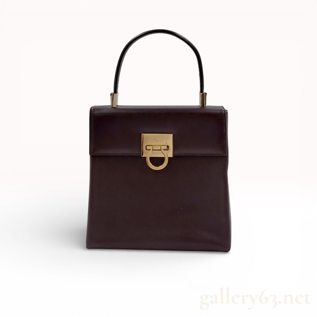 Salvatore Ferragamo Gancini Brown Leather Top Handle Handbag: Authentic Salvatore Ferragamo top handle handbag in dark brown leather, featuring a structured rectangular silhouette with a front flap closure. The bag is accented with the signature gold-tone Gancin