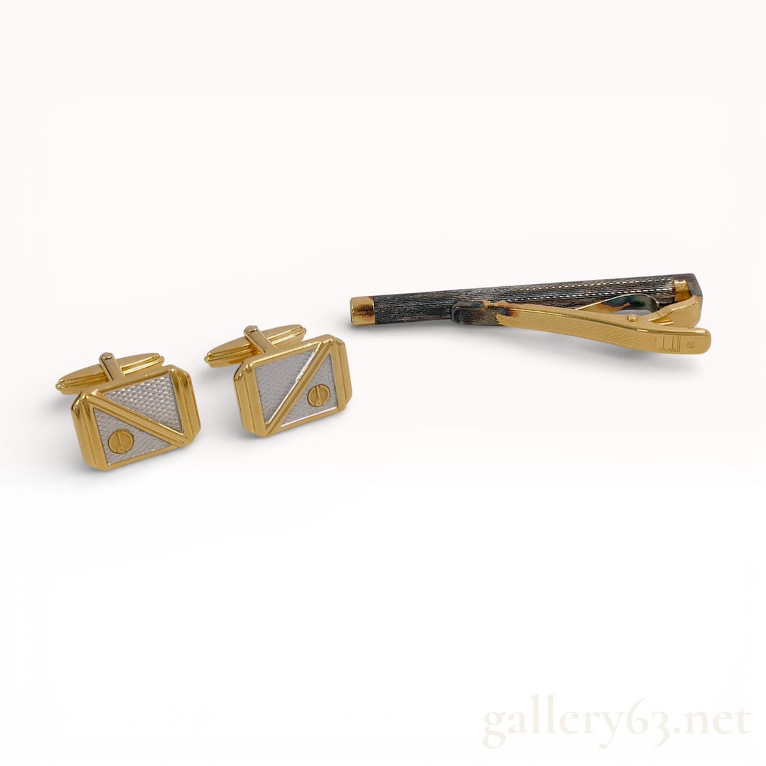 Dunhill Gold-Tone Tie Bar and Cufflinks Set with Geometric Inlay: Dunhill accessories set including a tie bar and matching pair of cufflinks in a gold-tone finish. Cufflinks featuring rectangular faces having a geometric triangular motif with contrasting textur