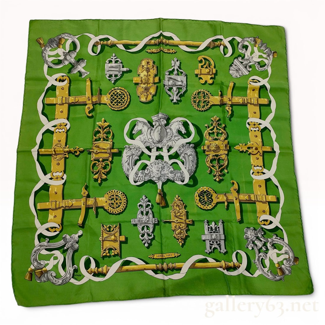 Hermès Carré 90 Silk Scarf in Green with Ornate Hardware and Strap Motif Ferronnerie: Hermès carré 90 silk scarf featuring an arrangement of ornate hardware, buckles, and strap elements in gold and silver tones against a vibrant green ground. Central symmetrical crest mot