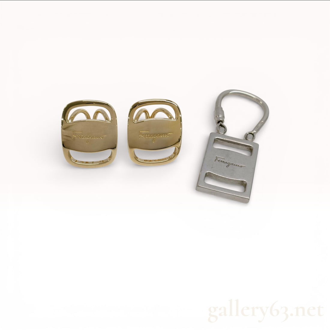 Salvatore Ferragamo Gold-Tone Gancini Clip Earrings and Logo Key Ring with Box: Salvatore Ferragamo accessory group featuring a pair of gold-tone Gancini clip earrings and a silver-tone logo key ring. Earrings having the signature double Gancini motif in openwork form with p