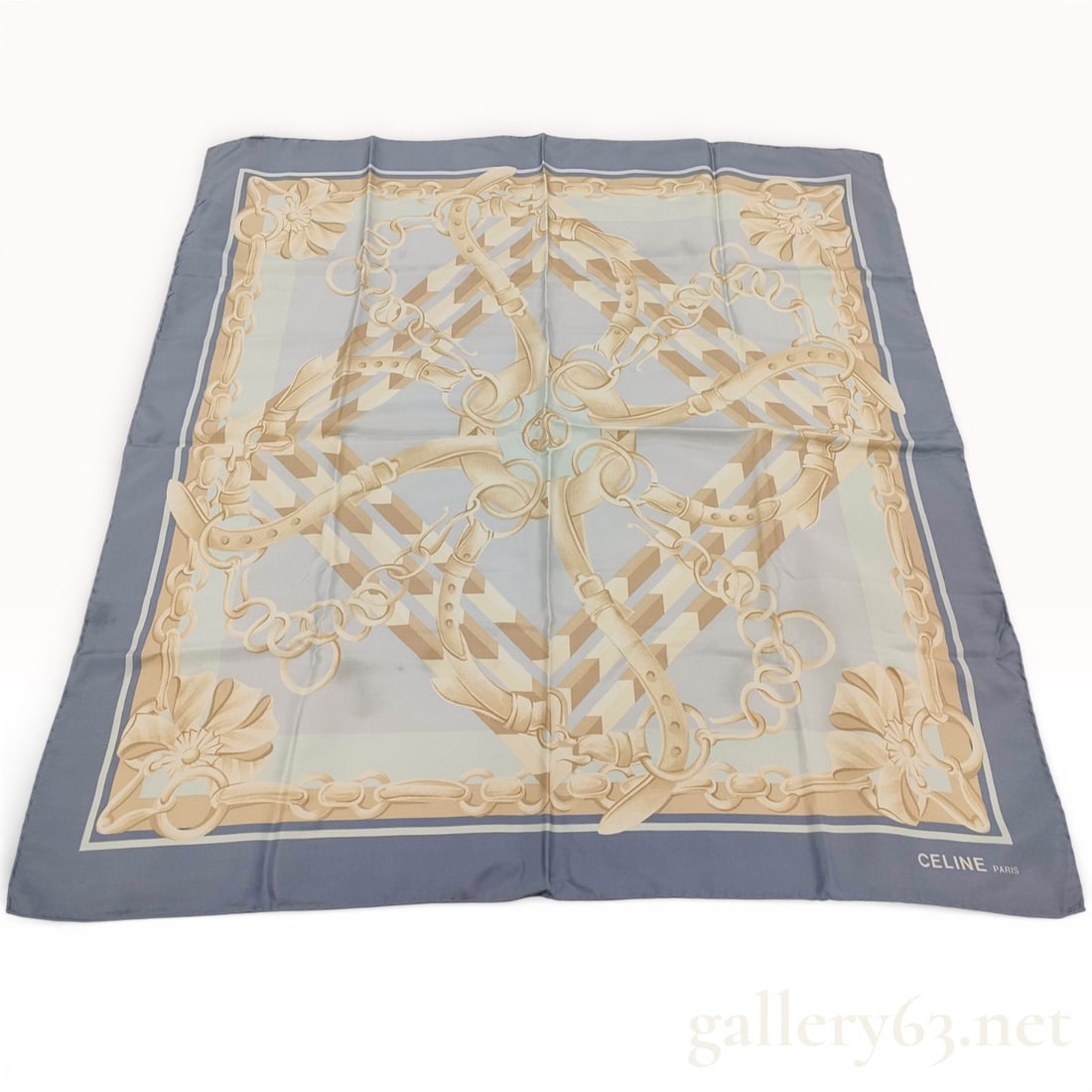 Celine Paris Silk Scarf with Equestrian Strap Motif in Blue and Cream: Celine Paris silk scarf featuring an interwoven equestrian strap and buckle motif in cream and gold tones set against a pale blue field. Wide slate blue border framing square format with layered trim
