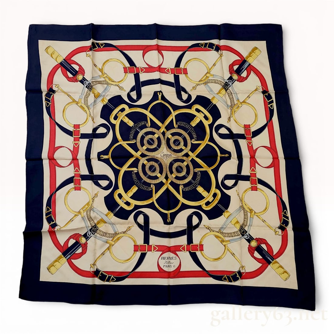 Hermès Carré Silk Scarf 90 "Éperon d'Or": Hermès carré silk scarf featuring an equestrian-inspired harness and bridle motif in navy, red, and gold tones against a cream ground. Central medallion design framed by interlocking
